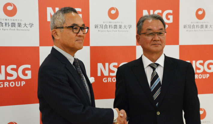 中井裕副学長と握手を交わす谷崎監督(右）